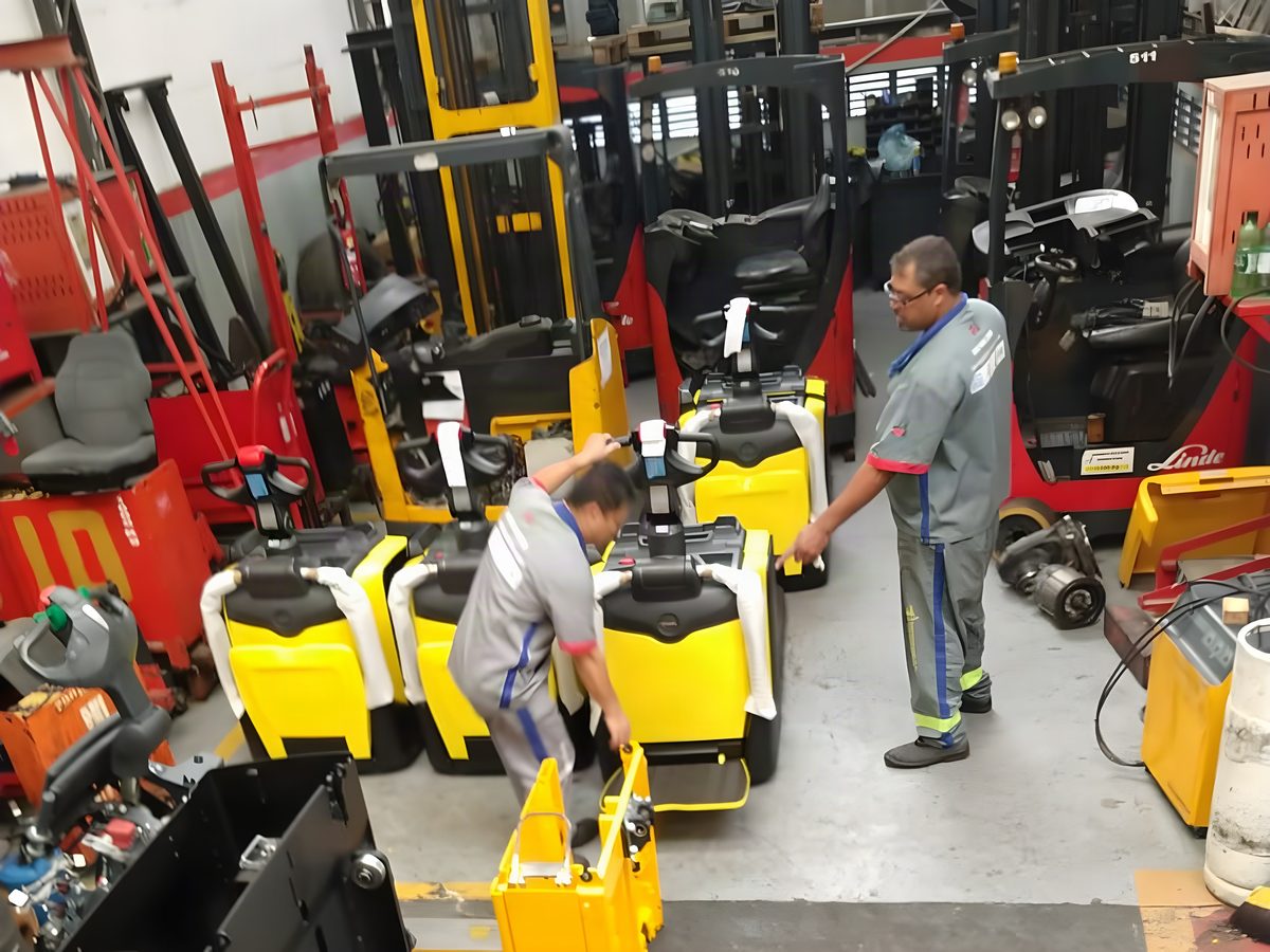 Técnicos da Motorep em serviço numa fila de paleteiras elétricas